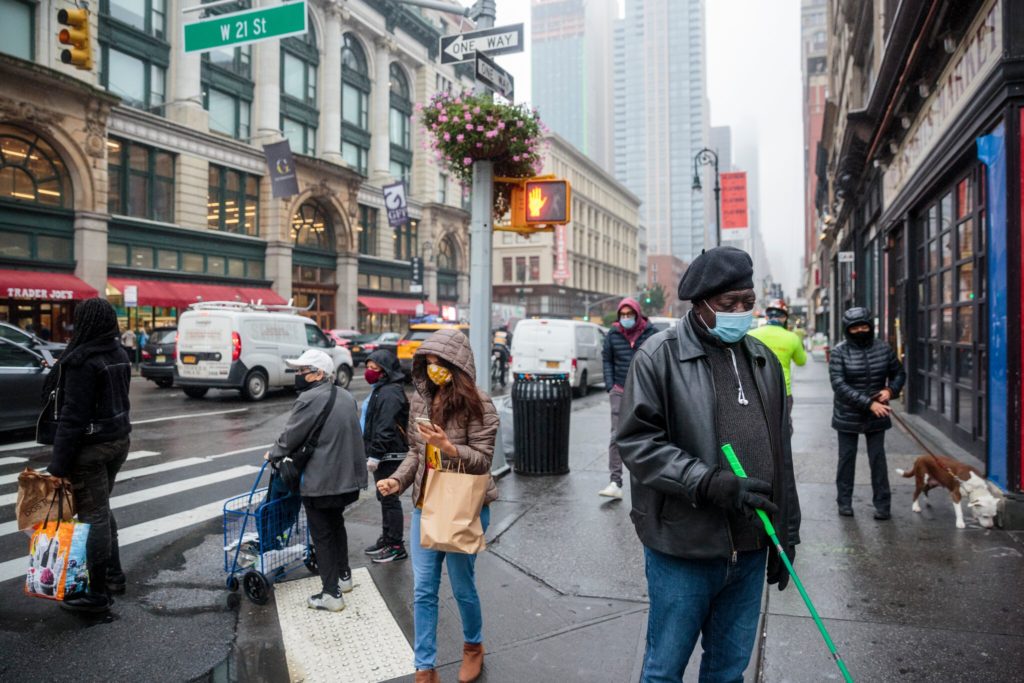 New York city street showing a color old man walking with a green cane