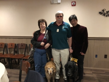 President Carol Holmes with dog guide Lyric, Vice President Larry Ashford with dog guide Quentin and Takashi Nakaya.