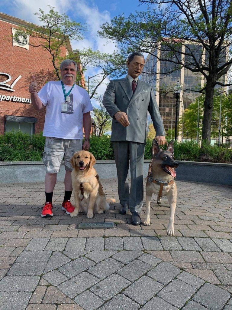 Larry and Quatro standing by the statue of Morris Frank in Morristown, NJ